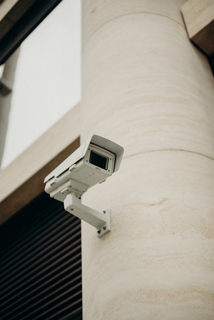 services-01 Close-up of a CCTV camera on a concrete building, symbolizing security and technology.